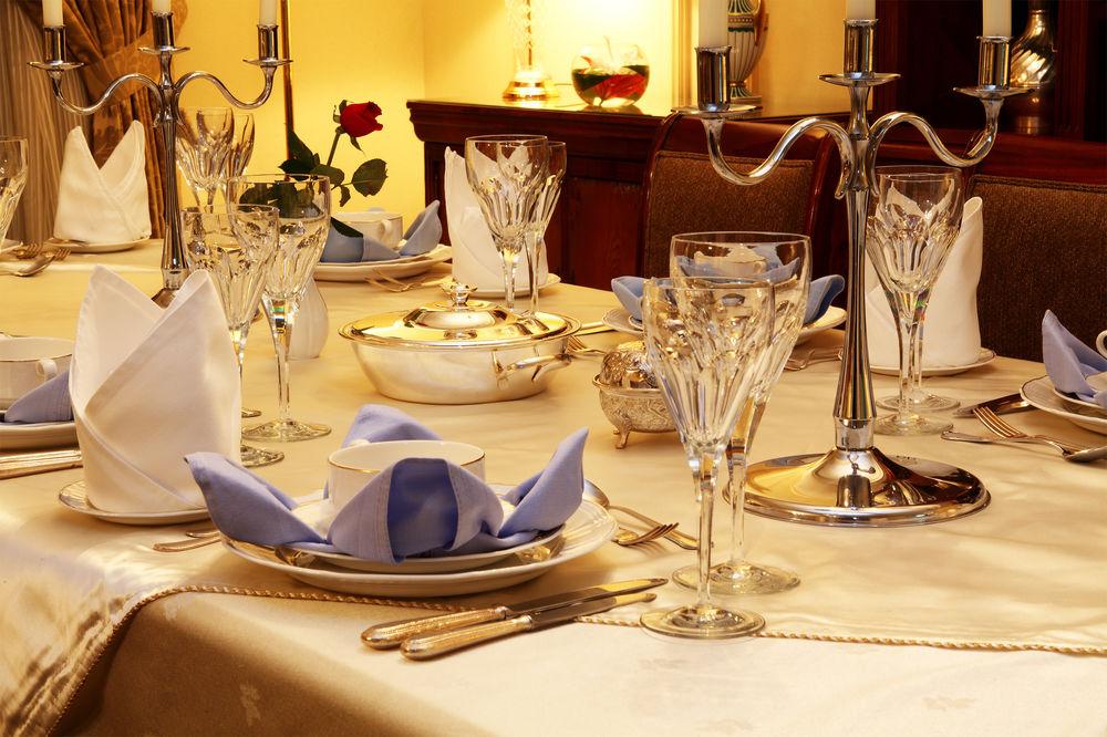 Intercontinental Dar Al Iman Madinah By Ihg Hotel Medina Eksteriør billede The image shows a beautifully arranged dining table set for a formal occasion. The table is covered with a light-colored tablecloth, and the place settings include elegant dinnerware, including plates and crystal glassware. 

Each place setting has f