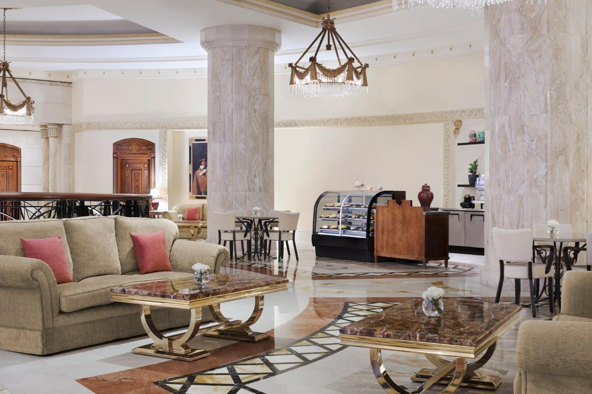 Intercontinental Dar Al Iman Madinah By Ihg Hotel Medina Eksteriør billede The image shows a spacious and elegantly designed hotel lobby or lounge area. It features plush sofas with cushions, stylish coffee tables, and decorative elements. The decor includes marble columns and a chandelier hanging from the ceiling, adding t