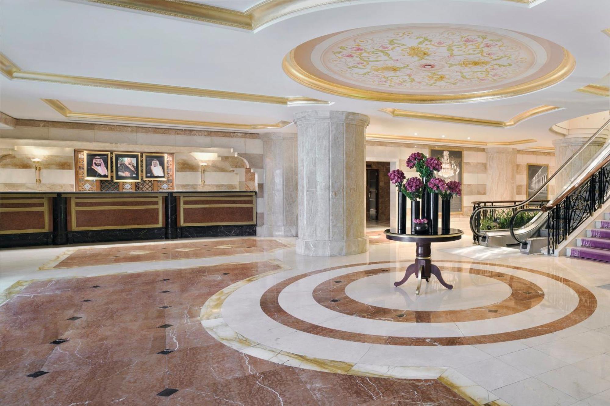 Intercontinental Dar Al Iman Madinah By Ihg Hotel Medina Eksteriør billede The photo shows a luxurious hotel lobby. The space features elegant marble flooring with circular designs, complemented by a large, decorative ceiling. In the center, there is a round table adorned with a floral arrangement. Behind the table, a recep